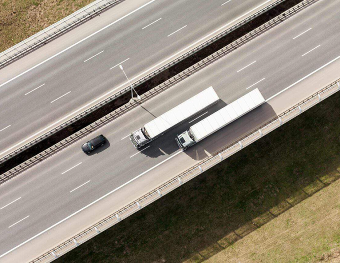 Two trucks and one car on a highway