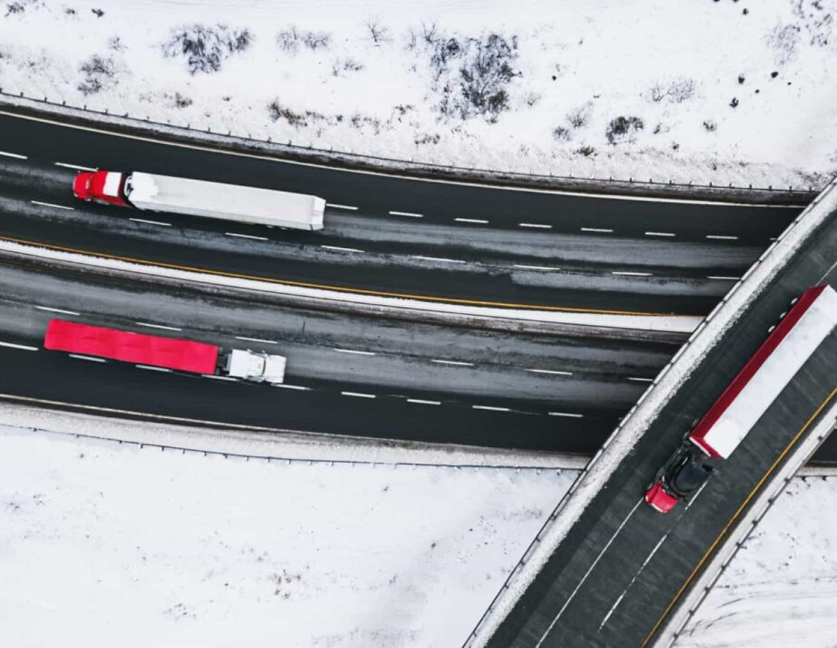 3 Trucks driving on a highway on-ramp